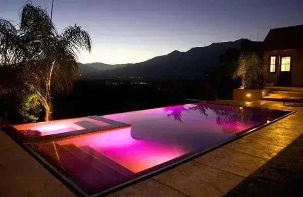 Piscina iluminada à noite em sítio de alto padrão